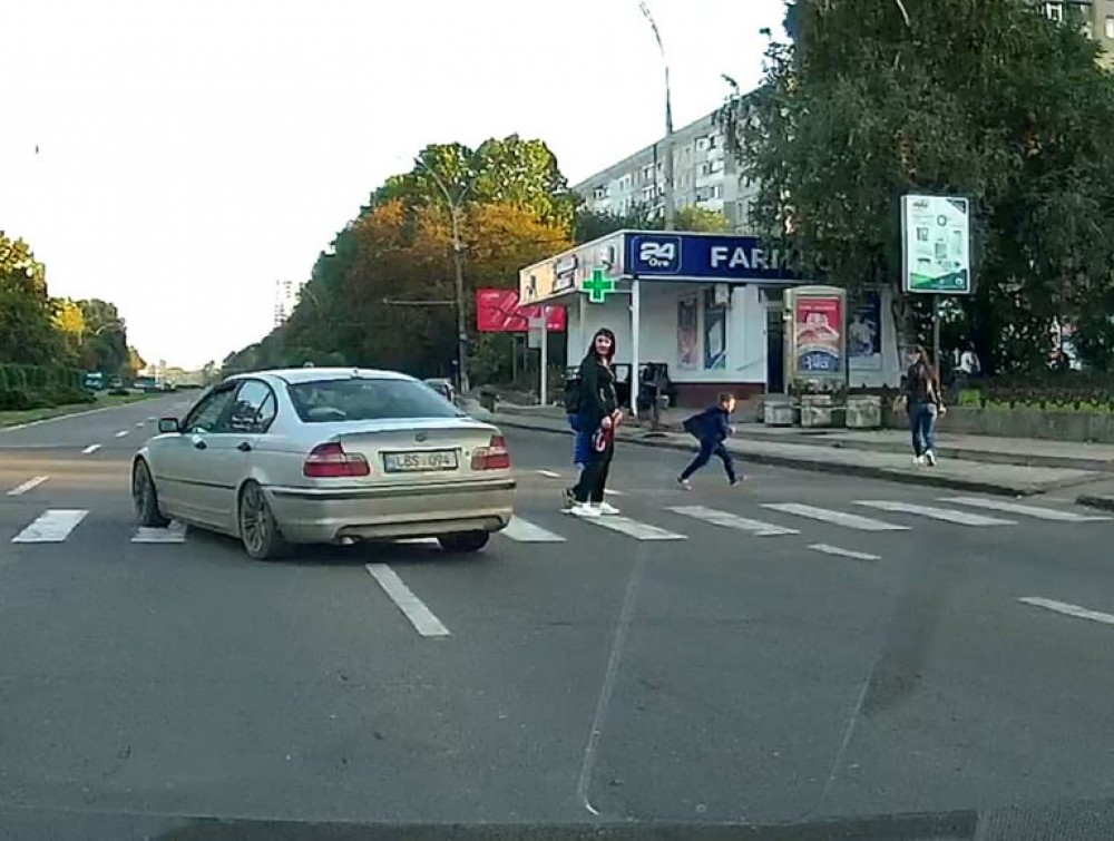 Un BMW cât pe ce să lovească o mamă cu 2 copii pe o trecere de pietoni