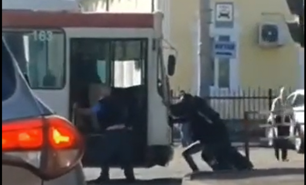 Momentul în care mai mulți oameni împing troleibuzul defectat din mijlocul străzii