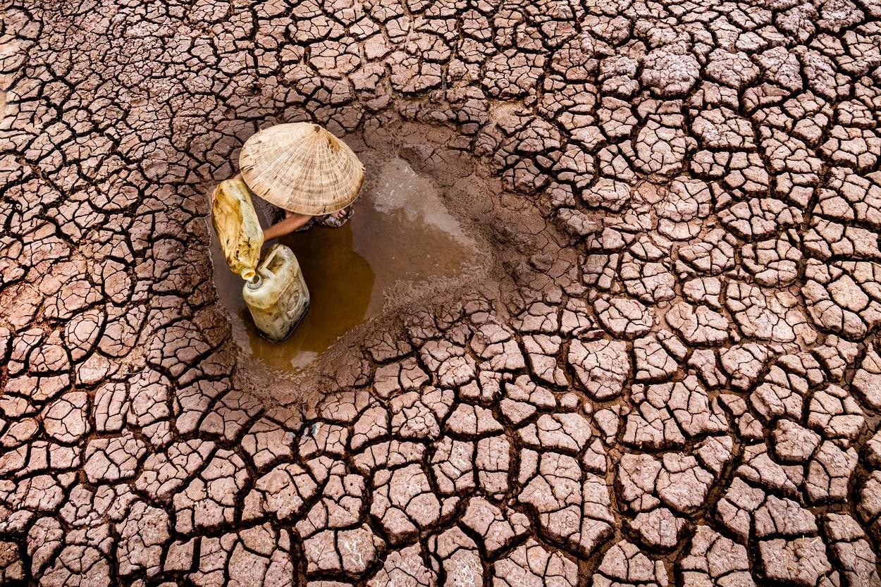 FOTO // Secetă cruntă în Vietnam. Imagini sfâşietoare cu un copil ce strânge ultimele picături de apă dintr-un lac secat pentru a le duce familiei