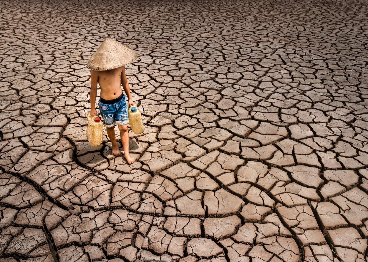 FOTO // Secetă cruntă în Vietnam. Imagini sfâşietoare cu un copil ce strânge ultimele picături de apă dintr-un lac secat pentru a le duce familiei