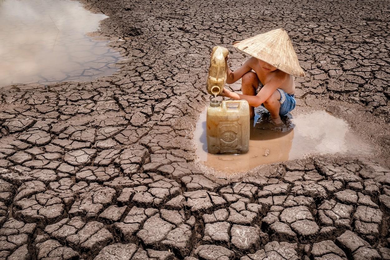 FOTO // Secetă cruntă în Vietnam. Imagini sfâşietoare cu un copil ce strânge ultimele picături de apă dintr-un lac secat pentru a le duce familiei