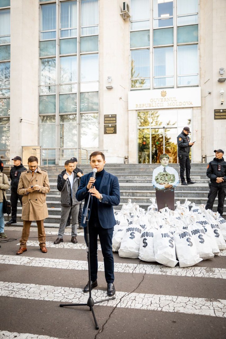 FOTO // Andrei Spînu - multimilionarul „vremurilor bune”, și-a adus sacii cu banii din offshore în fața Guvernului, în cadrul unui flashmob al Partidului „ȘOR”