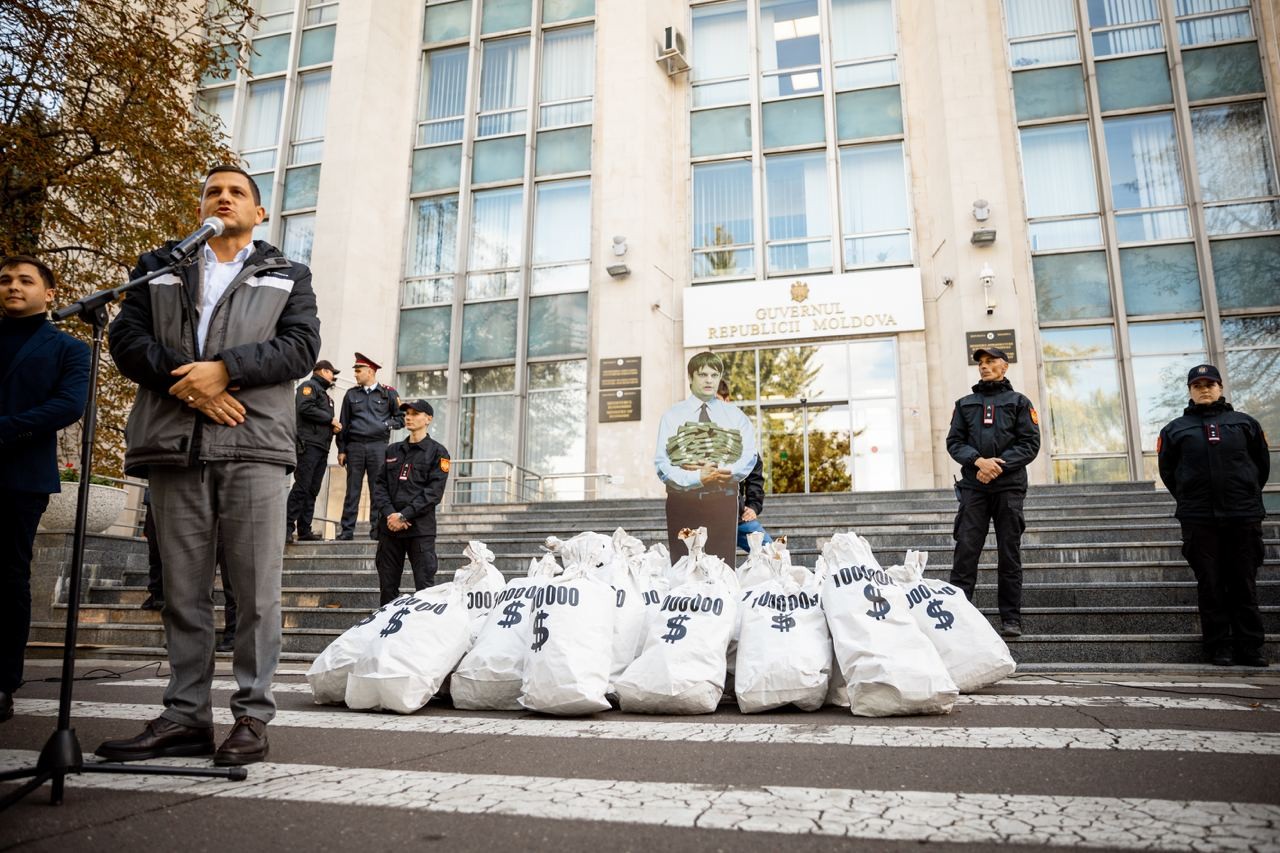 FOTO // Andrei Spînu - multimilionarul „vremurilor bune”, și-a adus sacii cu banii din offshore în fața Guvernului, în cadrul unui flashmob al Partidului „ȘOR”