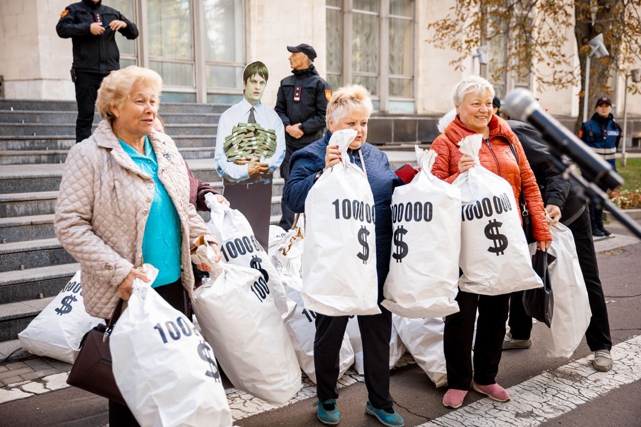FOTO // Andrei Spînu - multimilionarul „vremurilor bune”, și-a adus sacii cu banii din offshore în fața Guvernului, în cadrul unui flashmob al Partidului „ȘOR”