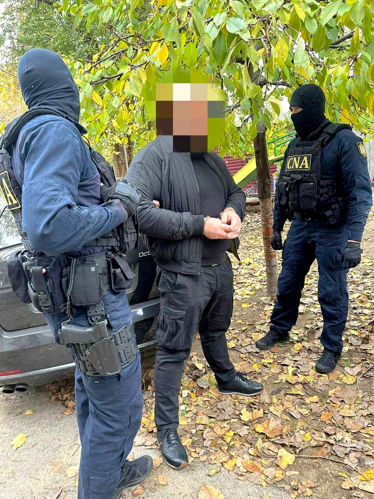 FOTO // Un ofițer de investigații, reținut de CNA în flagrant, cu mită de 2000 de euro